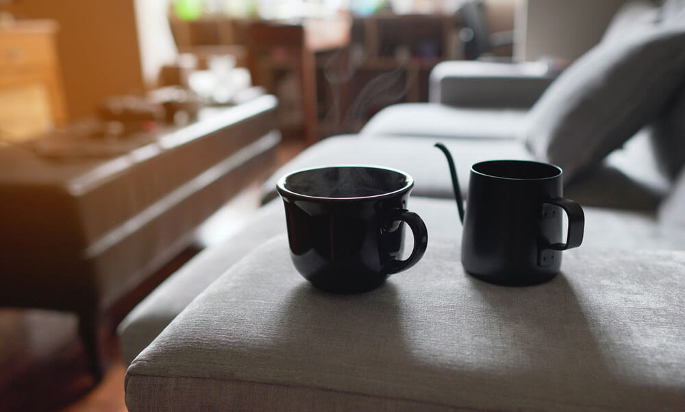 Photo of a cup and pot of tea on a couch