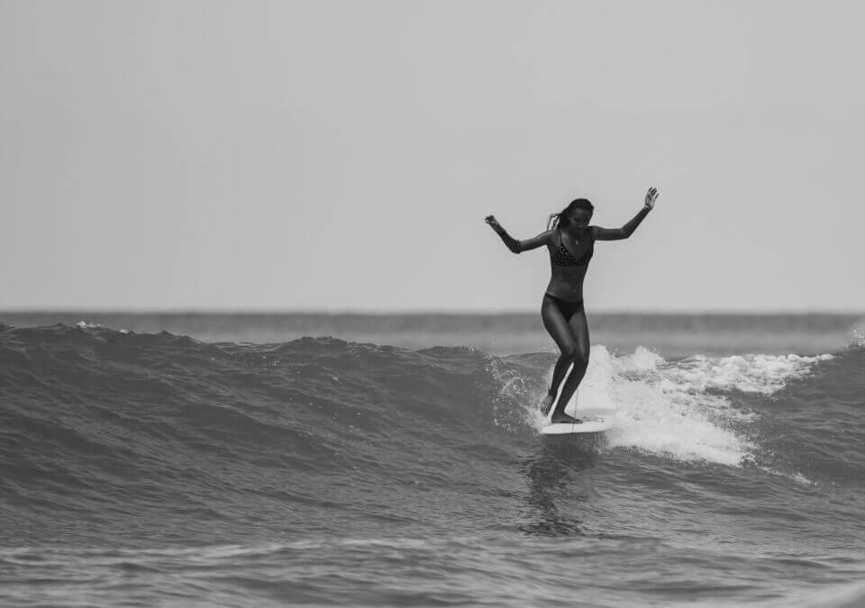 Woman surfing in a black and white phot