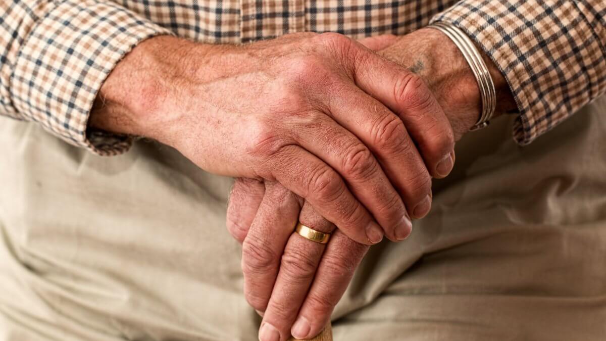 Picture of an aging parent’s hands holding a cane